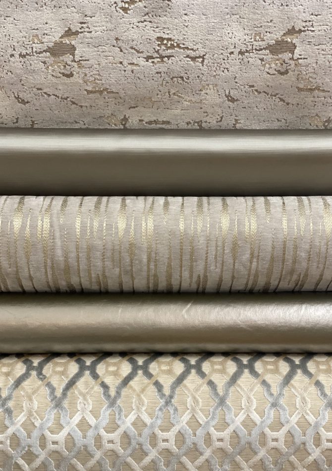 Stacked rolls of textured upholstery fabric.