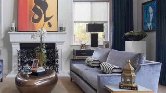 Elegant living room with modern furniture and vibrant artwork above the fireplace.