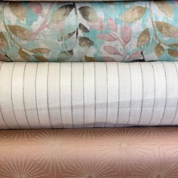 Three rolls of wallpaper with different patterns and colors.