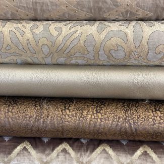 Stack of folded fabrics with various textures and patterns.