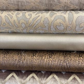 Stack of folded fabrics with various textures and patterns.