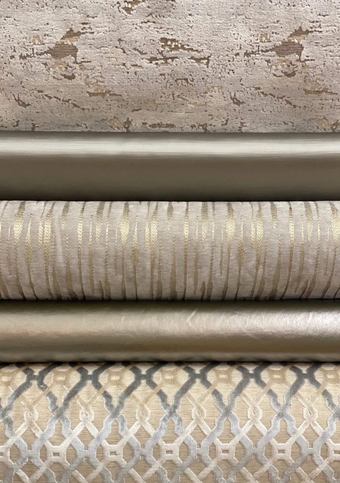 Three textured fabric rolls in neutral tones stacked horizontally.