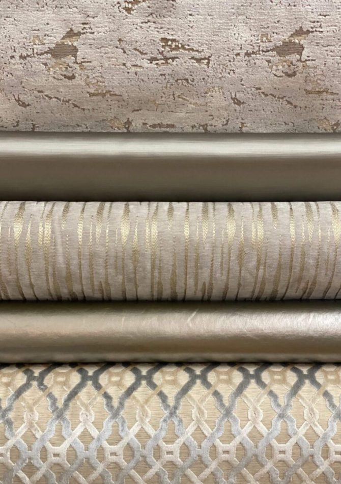 Three textured fabric rolls in neutral tones stacked horizontally.